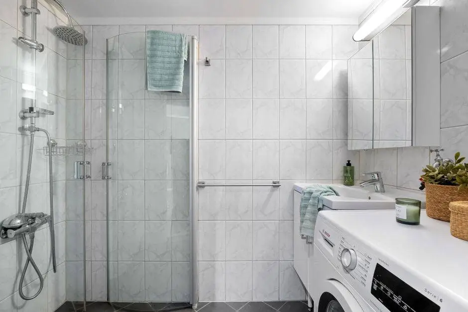 Clean and minimalistic bathroom featuring a shower, sink, and laundry area.