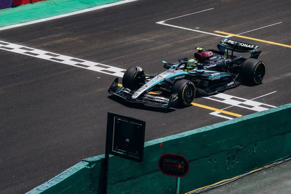 High-speed Formula 1 car crossing the finish line on a race track during the day.