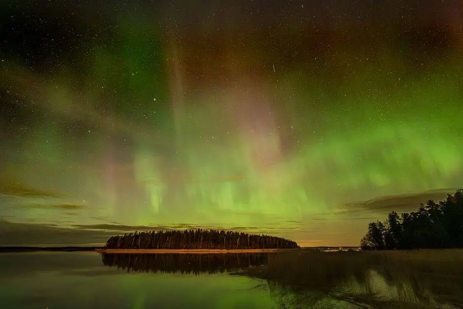 Aurora Borealis glowing vividly over a serene lake in Askainen, creating a mesmerizing natural display.