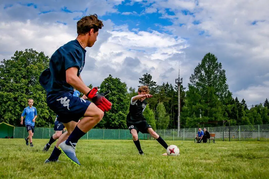 Young athletes engaged in an energetic soccer game outdoors on a grassy field.